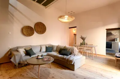 a living room with a couch and a table at Monastery apartment, a unique house in Chania Town