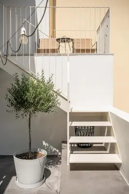 a plant in a white pot next to a staircase at Lofos Casteli Sunlight in Chania Town