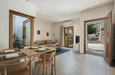 a dining room and living room with a table and chairs at Lofos Casteli Sunlight in Chania Town