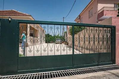 a green gate with a person standing behind it at Olga's Organic garden Home for a couple! with Wifi & AC in Chania Town