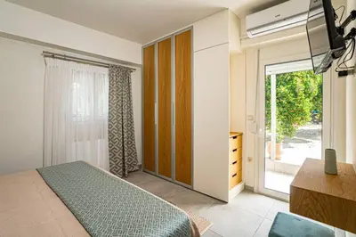 a bedroom with a bed and a sliding glass door at Olga's Organic garden Home for a couple! with Wifi & AC in Chania Town