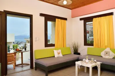 a living room with two couches and a table at SHINE VERANDA PRIVE APTS 7PERSONS in Plataniás