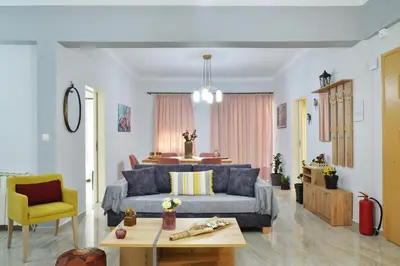 a living room with a blue couch and a yellow chair at Aristea's Apartment 2nd Floor in Chania Town