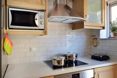 a kitchen with two pots on a stove with a microwave at Aristea's Apartment 2nd Floor in Chania Town