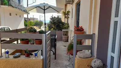 a balcony with potted plants and an umbrella at Kissamos Nice Apartment1 in Kissamos