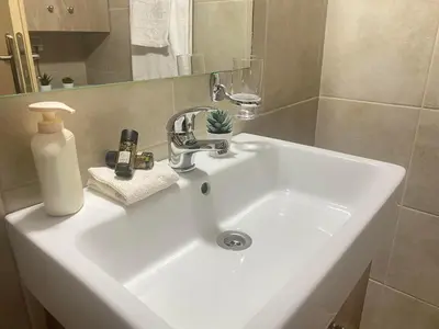 a white sink in a bathroom with a mirror at Kissamos Nice Apartment1 in Kissamos