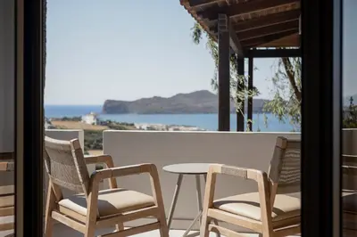 a table and chairs on a balcony with a view of the ocean at Chrissida Hotel in Agia Marina Nea Kydonias