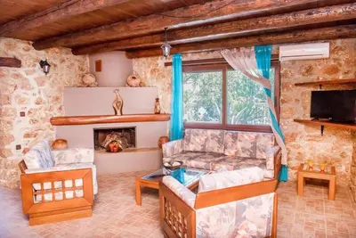 a living room with a couch and a fireplace at Villa Akrolithos with Private Pool in Chania Town