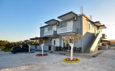 a house with two trees in front of it at KOYNTOYRA ROOMS in Kountoura Selino