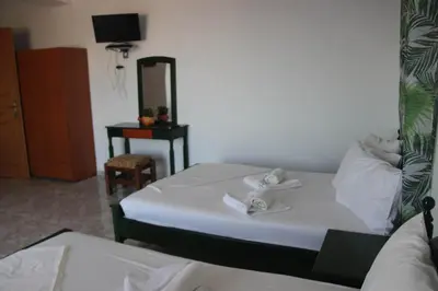 a bedroom with two beds and a table with a mirror at KOYNTOYRA ROOMS in Kountoura Selino