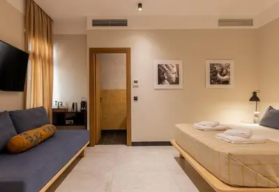 a bedroom with a bed and a couch at Flâneur in Chania Town