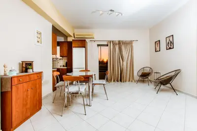 a kitchen and dining room with a table and chairs at Chania Grand Nature Apartment in Chania Town