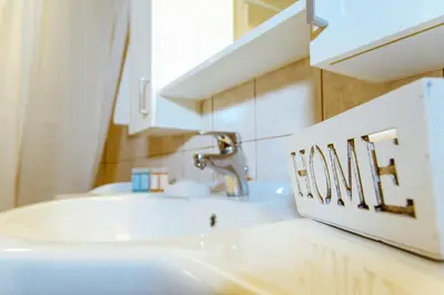 a bathroom with a white sink and a mirror at Chania Grand Nature Apartment in Chania Town