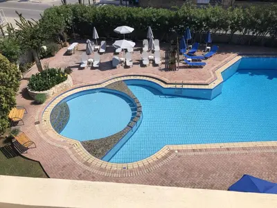 an overhead view of a swimming pool with chairs and umbrellas at Lefka Apartments in Parigoría