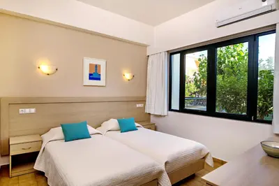 two beds in a room with two windows at Lefka Apartments in Parigoría