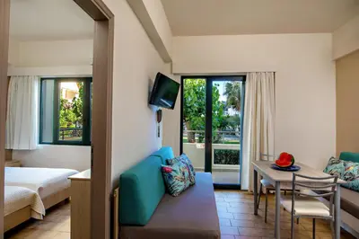 a hotel room with a bed and a table and a couch at Lefka Apartments in Parigoría