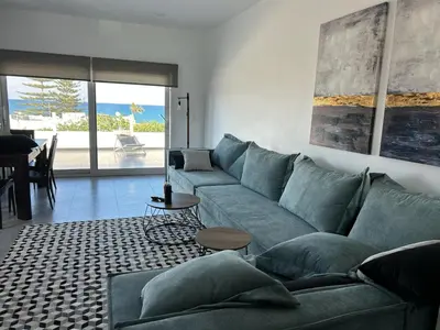 a living room with a blue couch and a table at Mira Sea View Residence in Chania Town