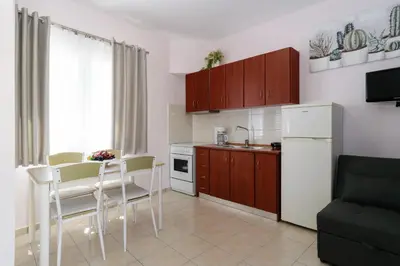 a kitchen with a white refrigerator and a table and chairs at Marianthi's Maisonette in Chania Town