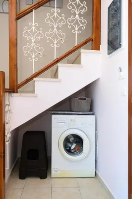 a laundry room with a washing machine under a staircase at Marianthi's Maisonette in Chania Town