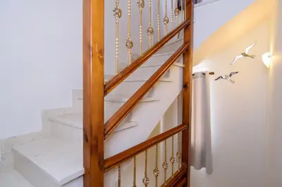 a stairway with a wooden rail and white stairs at Marianthi's Maisonette in Chania Town
