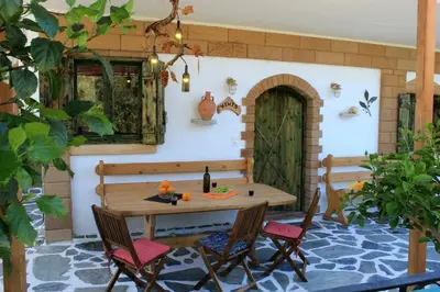 a patio with a wooden table and chairs at Village Villa Mimis Drapanias in Drapaniás