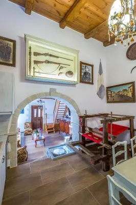 a living room with a stone fireplace and a chandelier at Traditional Cretan Villa George - Private Pool in Kambánion