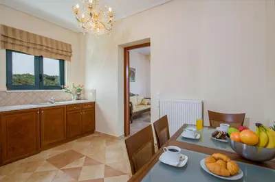a kitchen with a table with a bowl of fruit on it at Hilltop Villa Kontomari in Kondomari