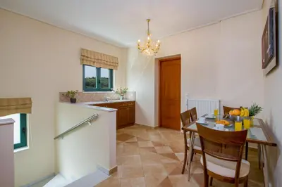 a kitchen and dining room with a table and chairs at Hilltop Villa Kontomari in Kondomari
