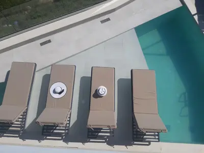 a row of chairs in a swimming pool at Luxury Villa Dioskouroi Heated eco pool & jacuzzi in Kalyves