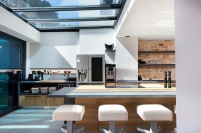 a kitchen with a counter with white stools at Cavo Dago in Chania Town