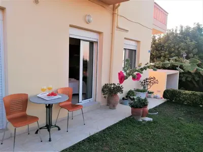 a patio with chairs and a table and a window at Emerald Apartment 2 Halepa in Chania Town