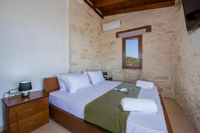 a bedroom with a large bed and a window at Lilium Stone Villa in Varípetron