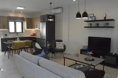 a living room with a couch and a table and a kitchen at Leonidas House in Chania Town
