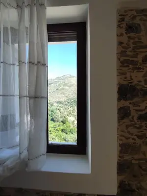 a window with a view of a mountain at Grandma Agatha & Virginia's stonehouse in Kefálion