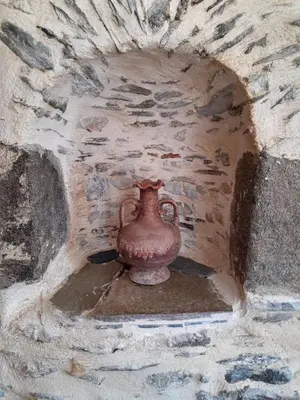 a vase sitting in a stone wall at Grandma Agatha & Virginia's stonehouse in Kefálion