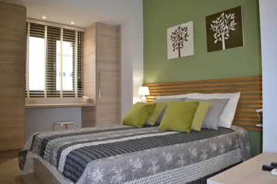 a bedroom with a large bed with green walls at Filia Luxury Apartment in Chania Town