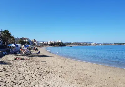 a beach with people laying on the sand and the water at Filia Luxury Apartment in Chania Town