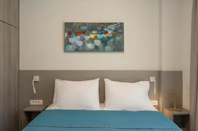 a bed with two pillows and a painting above it at Ethereal Villas Chania in Daratso