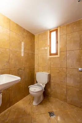 a bathroom with a toilet and a sink and a window at Ohana in Kamisianá