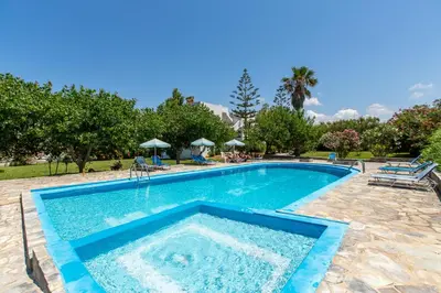 a swimming pool in a resort with trees and bushes at Ohana in Kamisianá