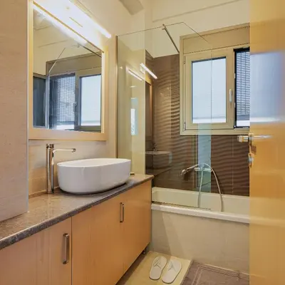 a bathroom with a white sink and a shower at Cypress Village - Lux villa 5' from beach in Daratso