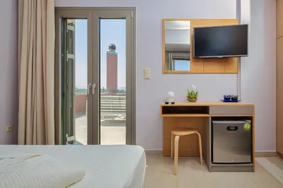 a bedroom with a bed and a desk with a tv at Cypress Village - Lux villa 5' from beach in Daratso
