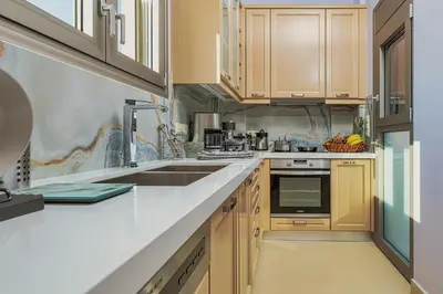 a kitchen with wooden cabinets and a sink at Cypress Village - Lux villa 5' from beach in Daratso