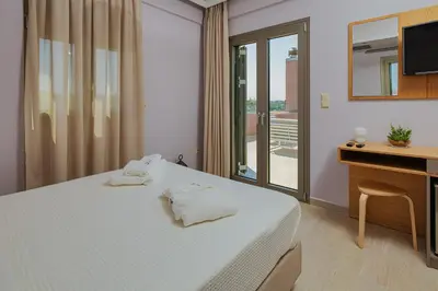 a bedroom with a bed and a desk and a television at Cypress Village - Lux villa 5' from beach in Daratso
