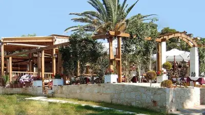a restaurant with a stone wall and a pavilion at Casa Nostos in Agia Marina Nea Kydonias