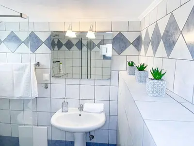 a white bathroom with a sink and two potted plants at Kampos View - Quiet House at the end of the Road, private pool in Kámbos