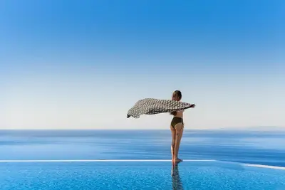 a woman standing in the water holding an umbrella at Villa Thetis Sfakia in Sfakiá