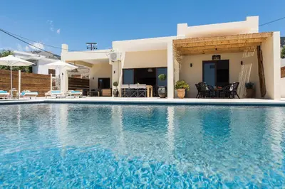 a villa with a swimming pool in front of a house at Villa Thetis Sfakia in Sfakiá