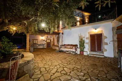 a courtyard of a white house at night at Villa Tzitzifes in Tzitzifés