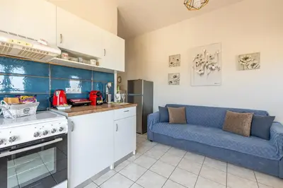 a kitchen with a blue couch in a kitchen at kissamos seaside bliss in Kissamos